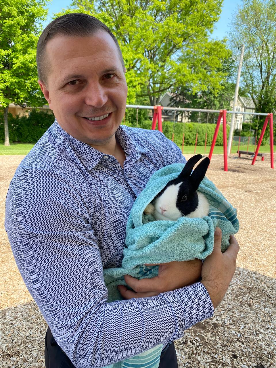 Smiling girl petting a fluffy white rabbit at a mobile petting zoo