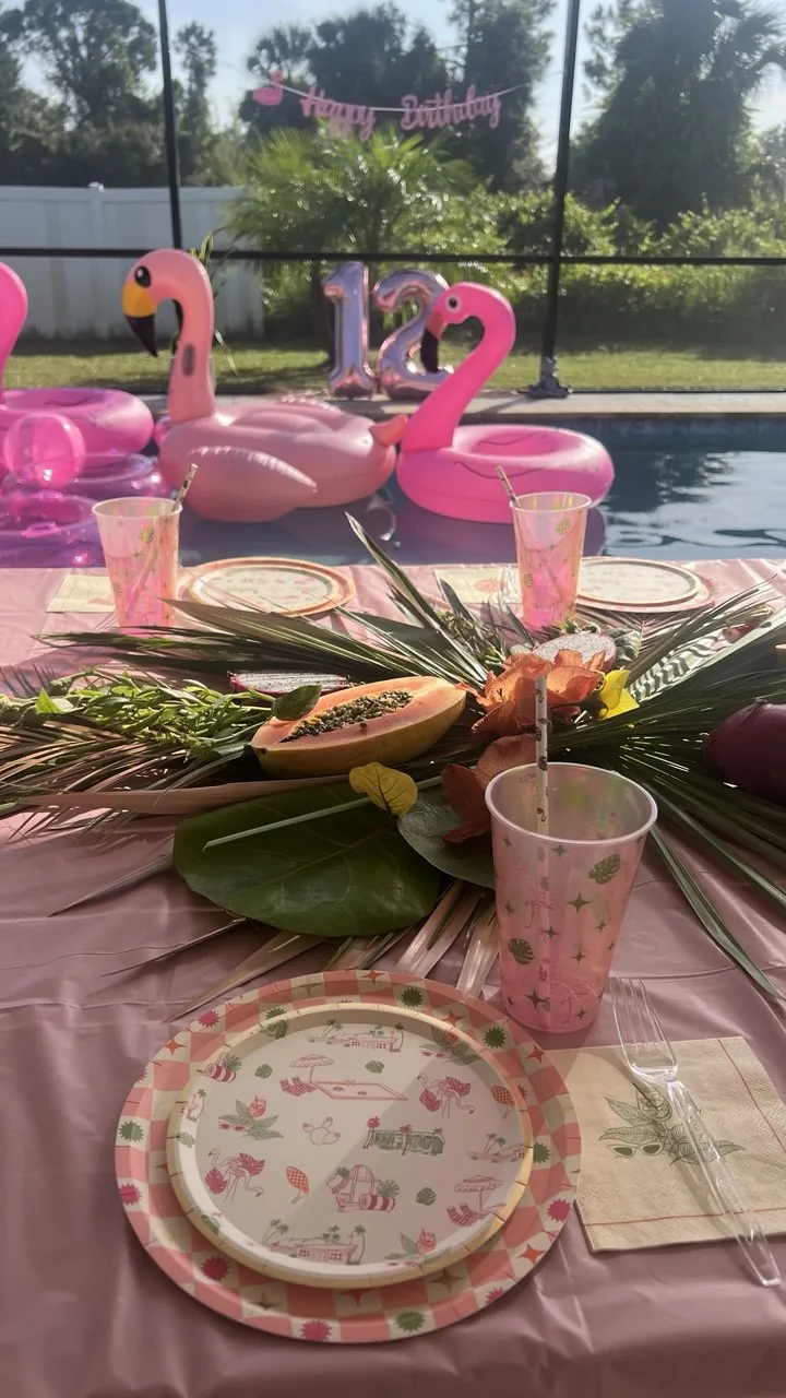 Pastel candy-themed birthday balloon arch with lollipop table decorations