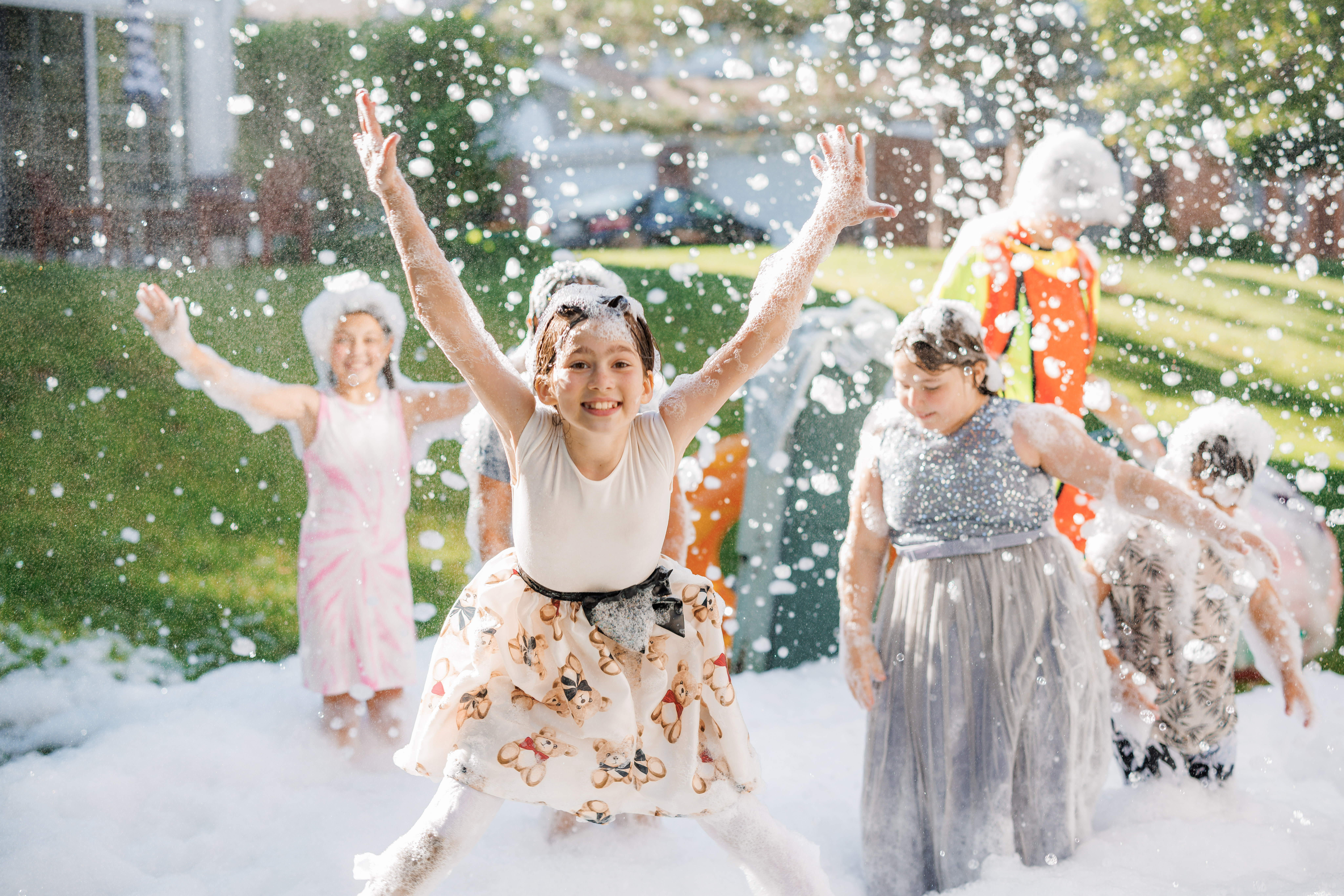 Children playing in a backyard foam party outdoors