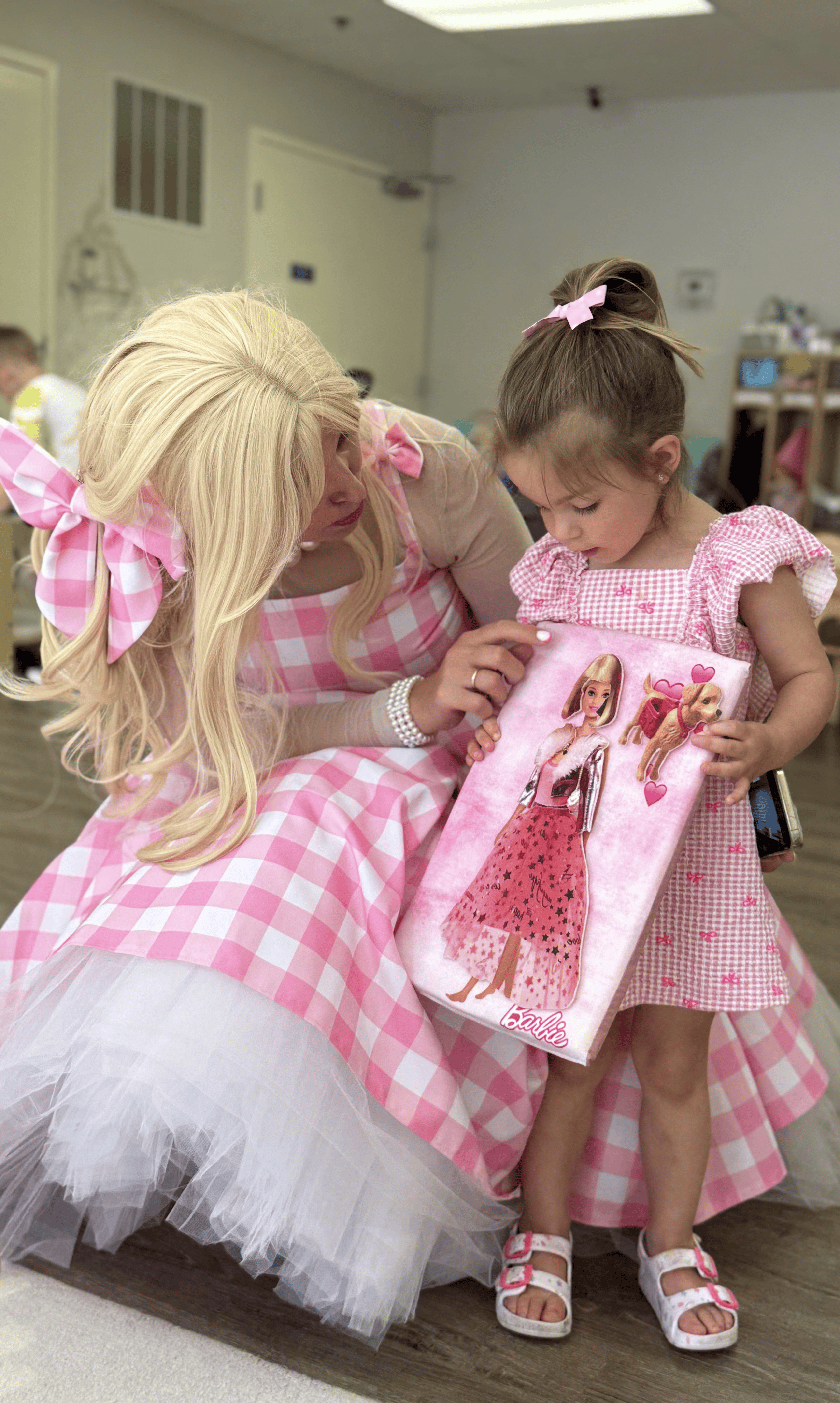 Child receiving a Barbie-themed gift from a costumed entertainer