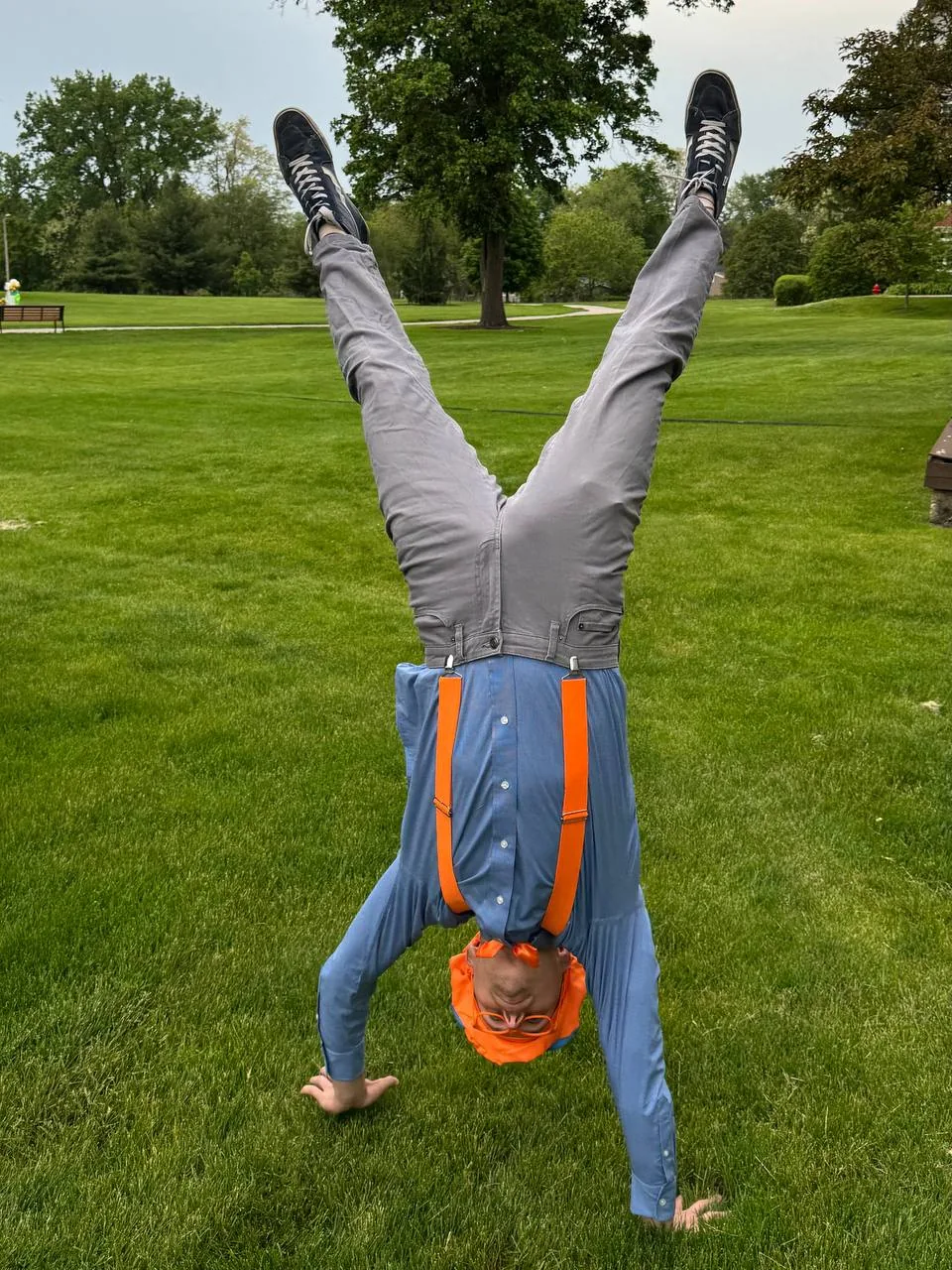 Performer doing a handstand in a Blippi-inspired costume at a kids event