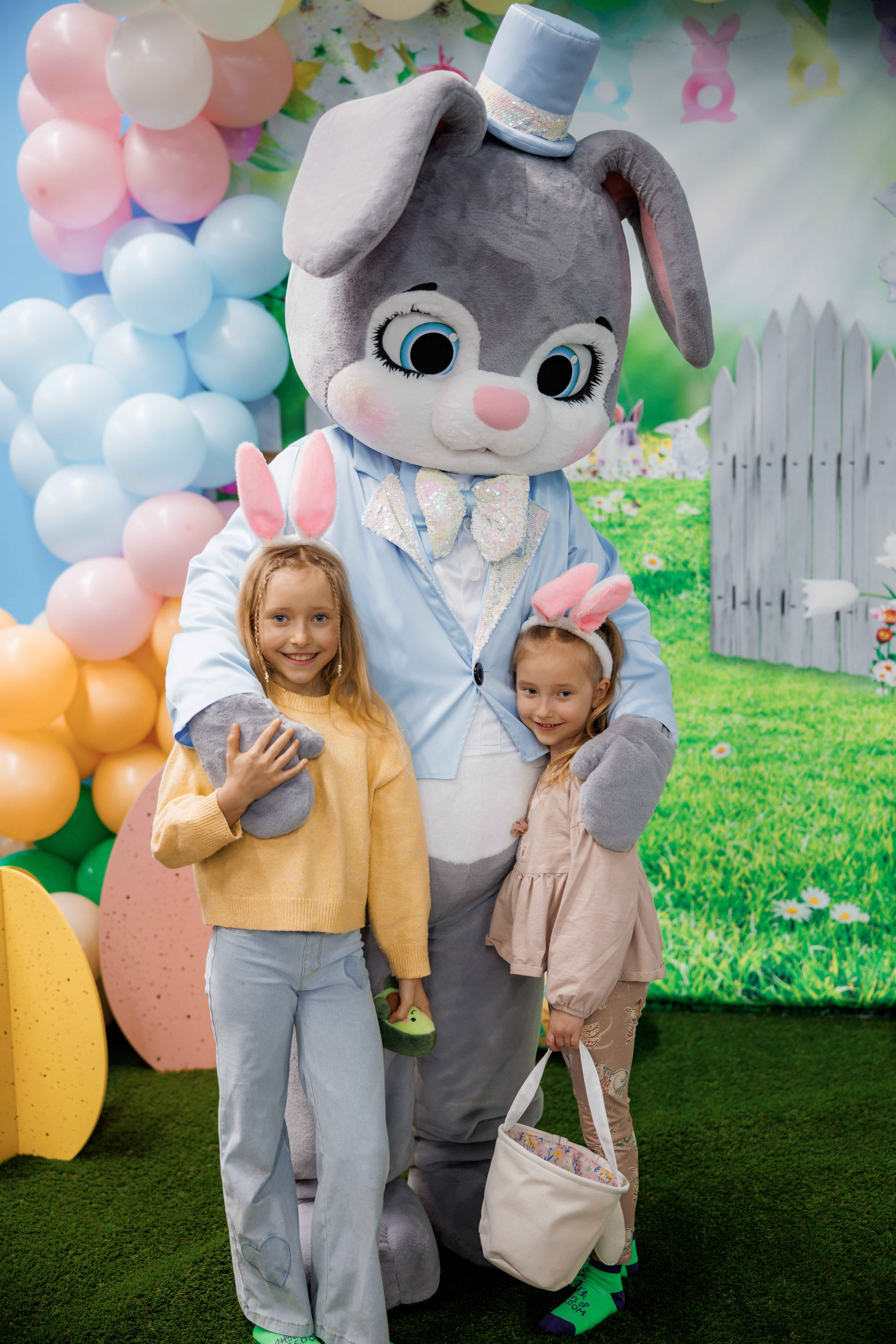 Easter bunny mascot posing with two girls wearing bunny ears