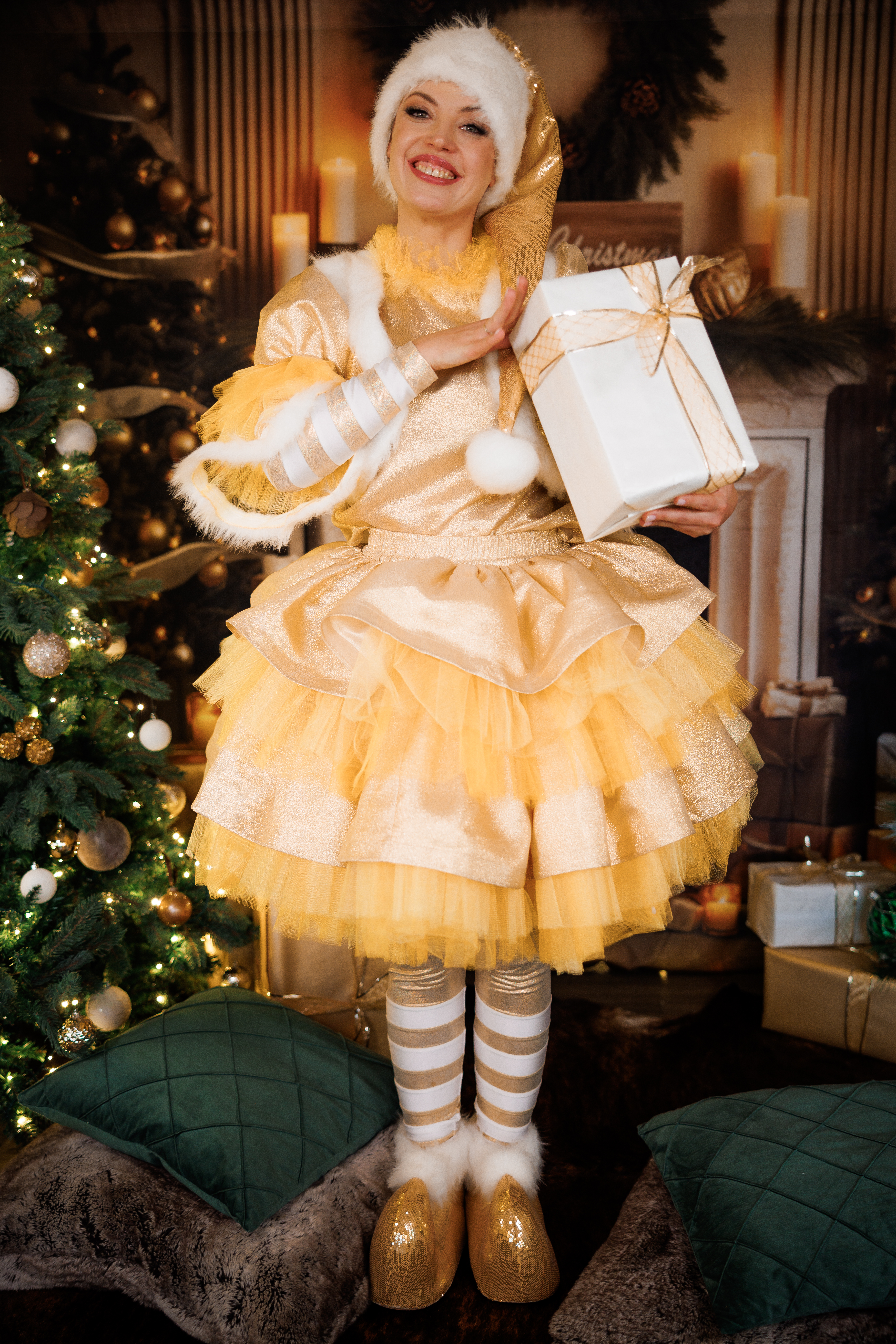 Christmas elf entertainer holding a gift in a festive holiday setting