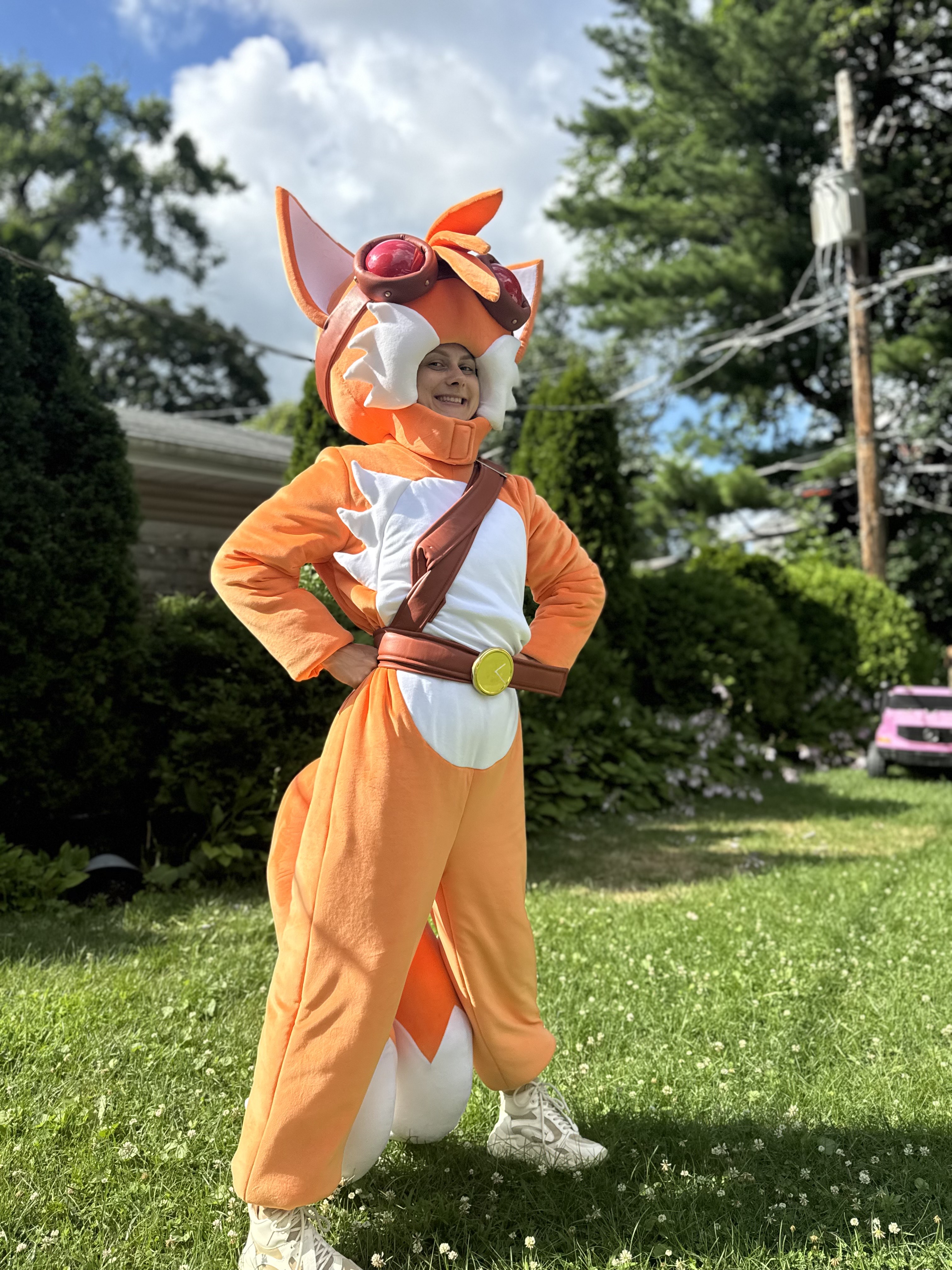 Fox character entertainer posing outdoors in a bright orange costume