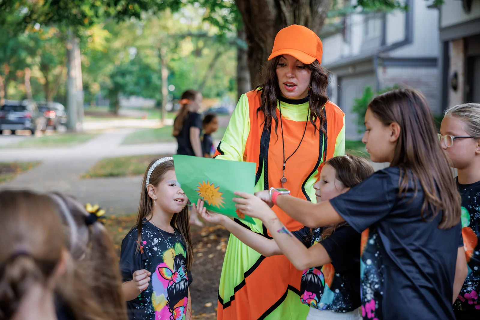 Neon party entertainer leading an outdoor activity with children