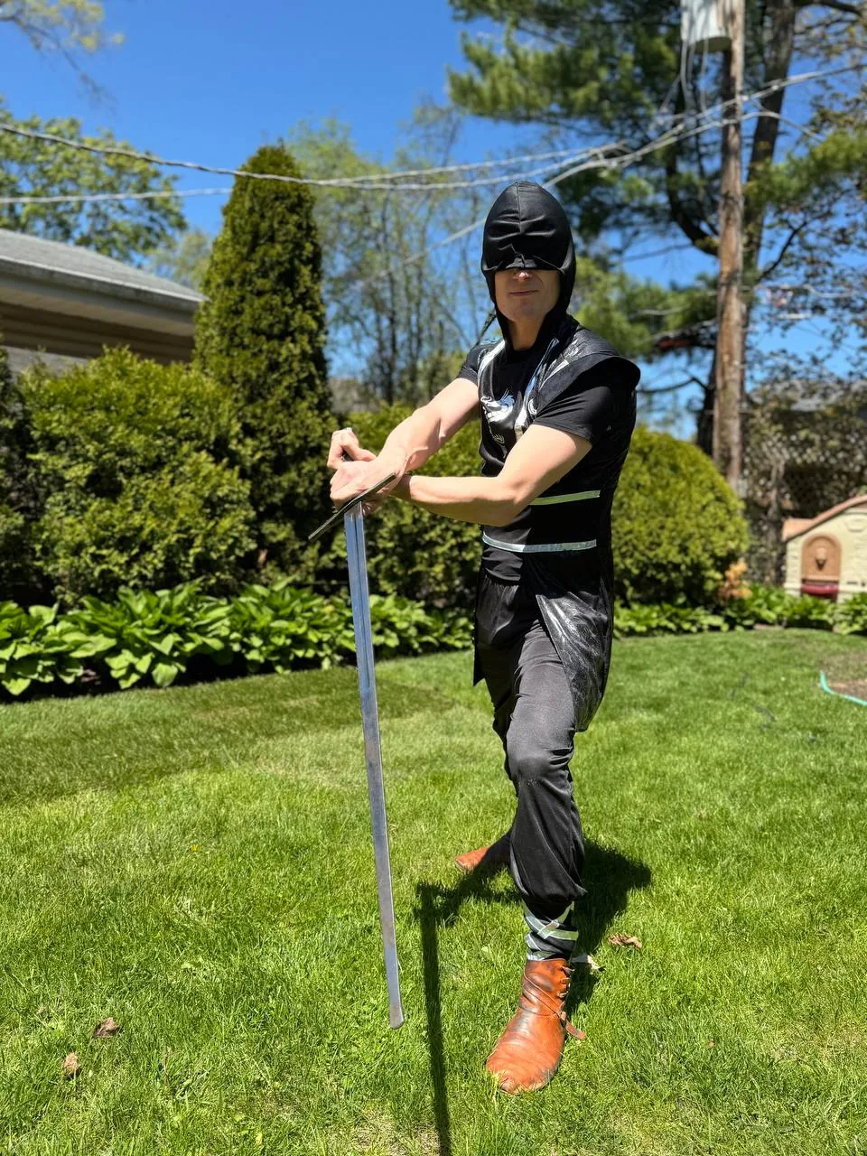 Ninja themed birthday party entertainer posing with a sword for kids event