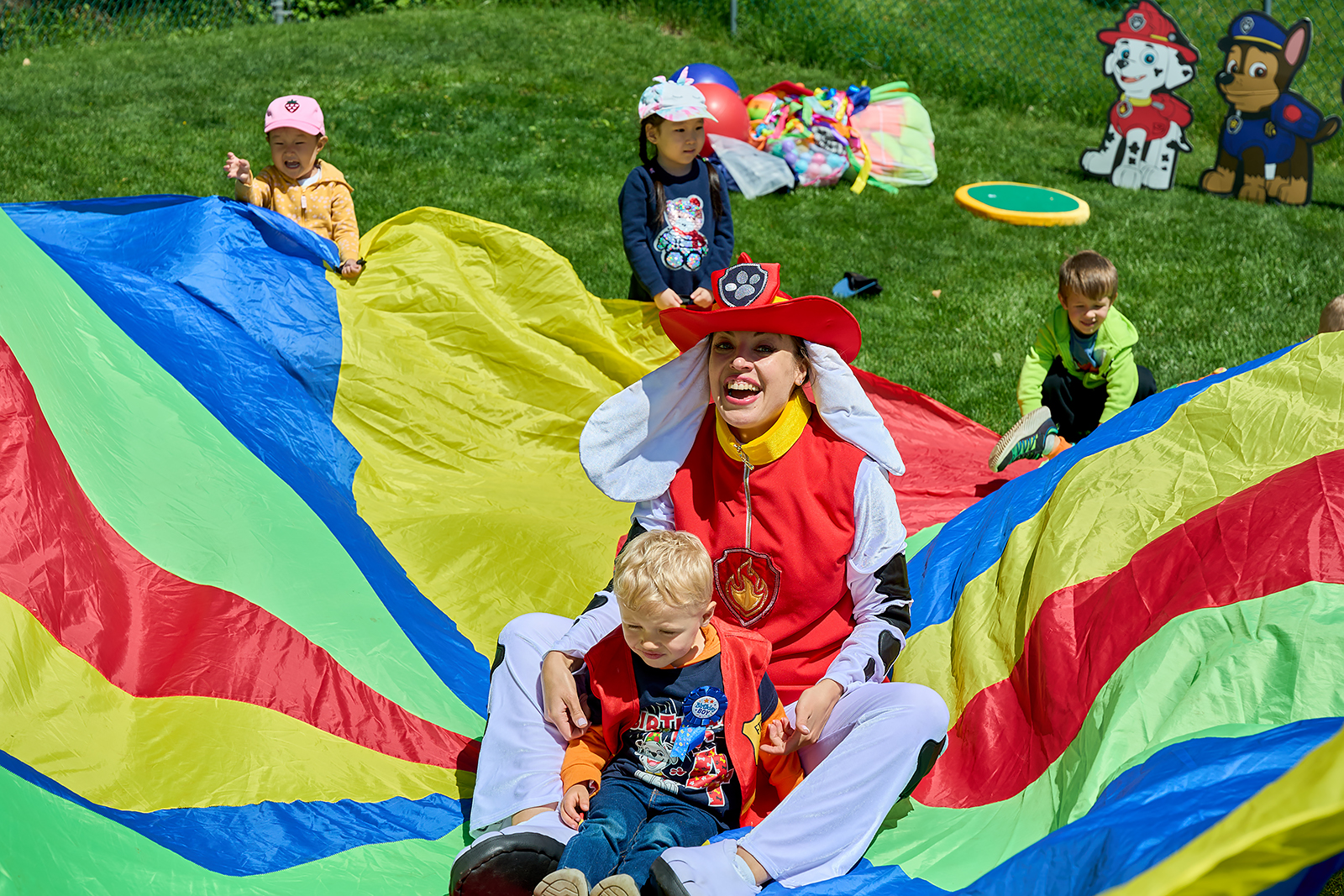 Paw Patrol Marshall kids party entertainer leading toddler game on parachute at birthday party in Illinois