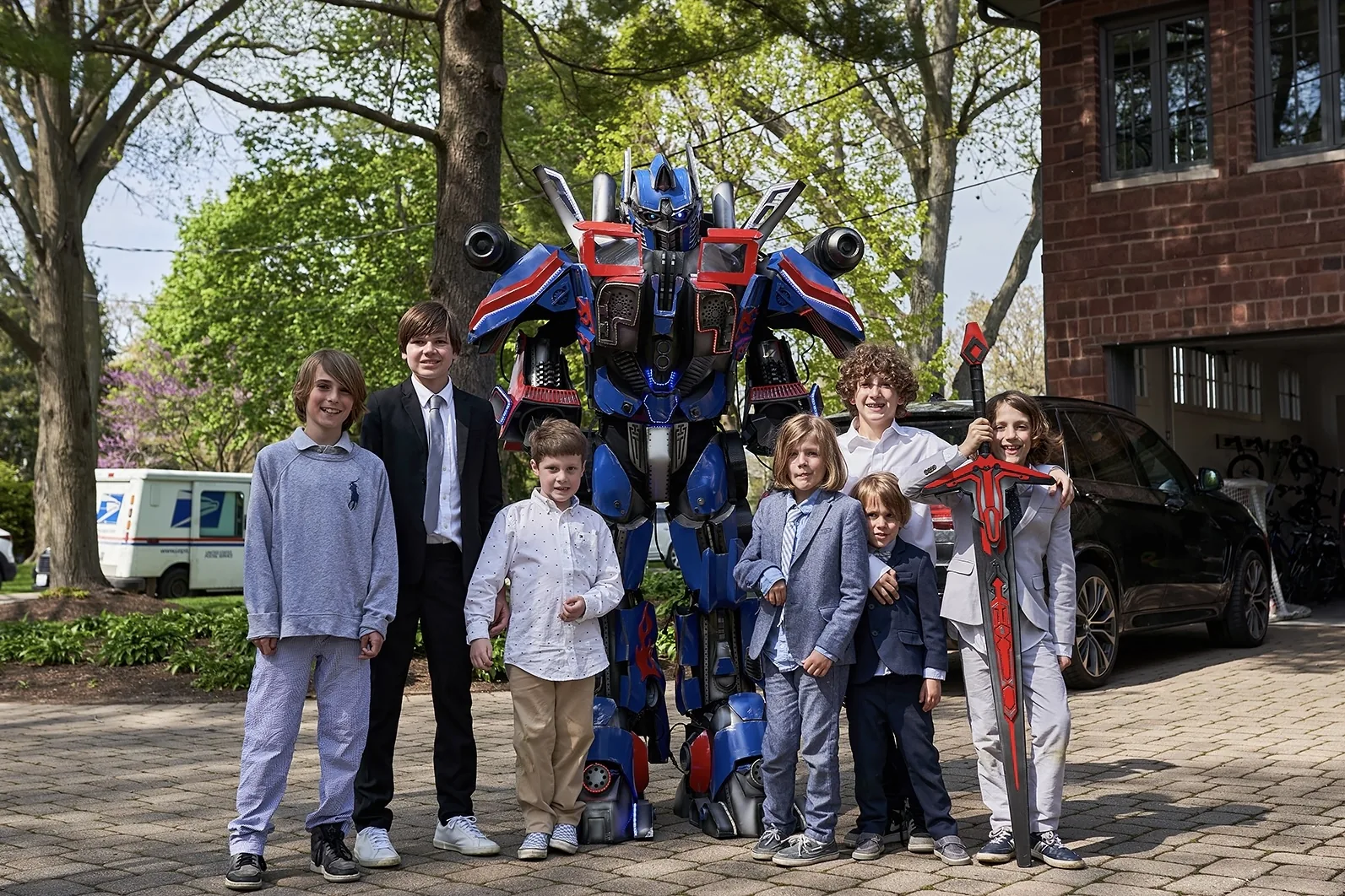 Kids posing with Optimus Prime robot entertainer at a birthday party