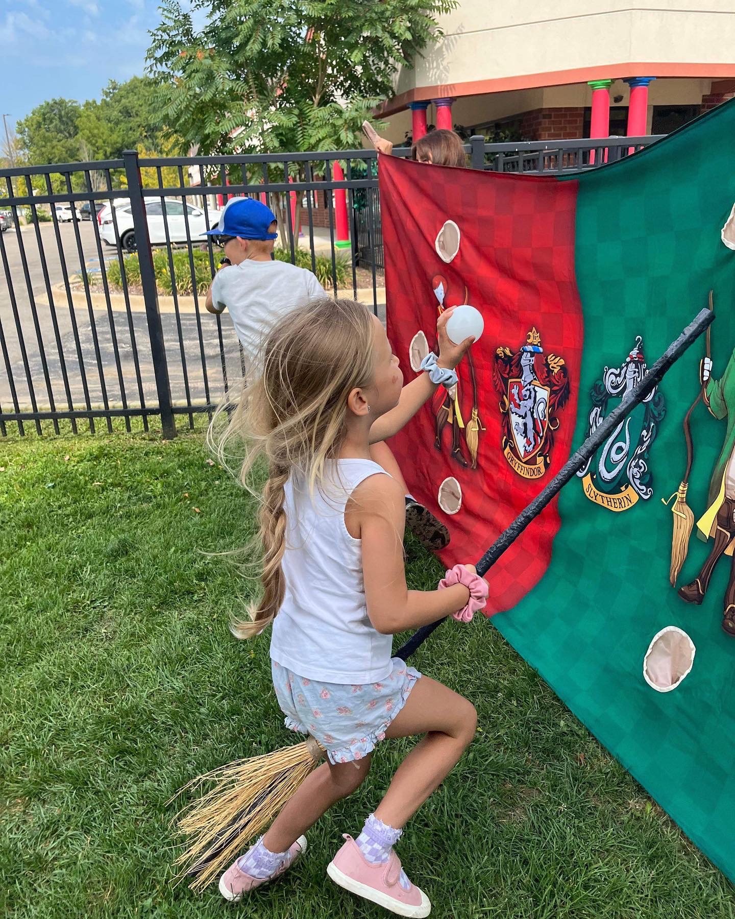 Kids playing a broomstick throwing game at a wizard event