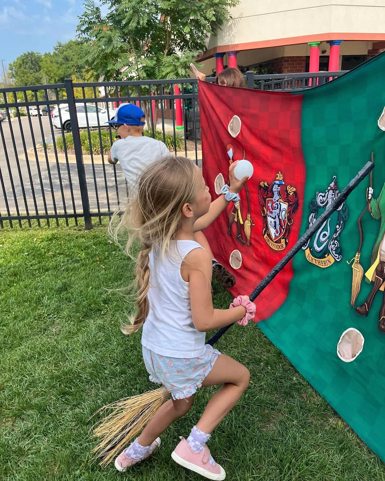 Kids playing a broomstick throwing game at a wizard event