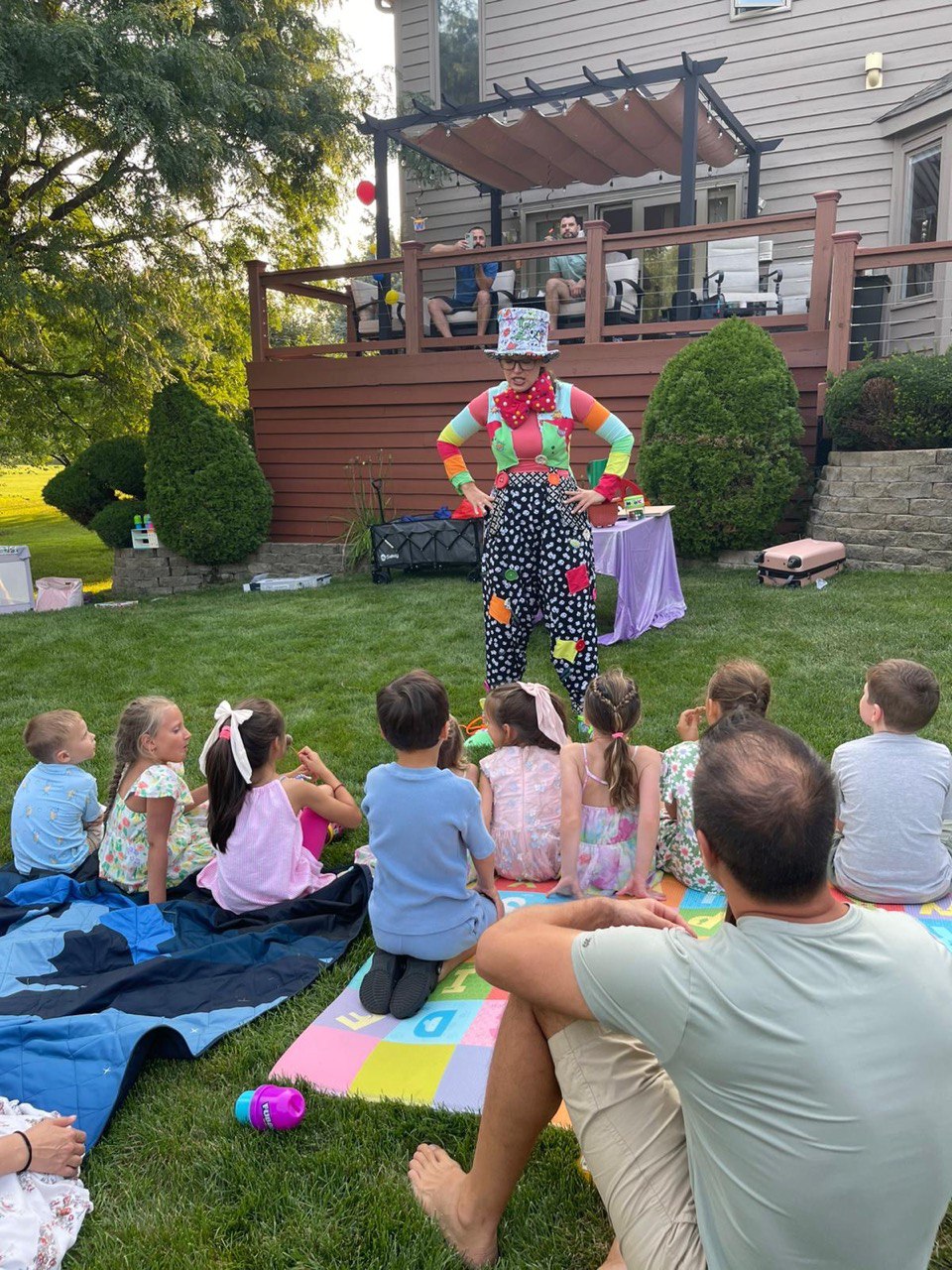 Children watching a clown performer at a backyard kids party