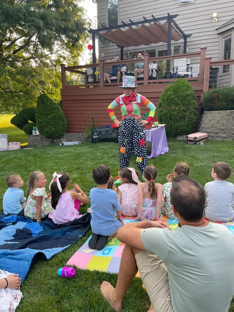 Children watching a clown performer at a backyard kids party